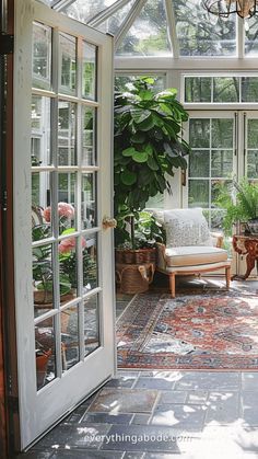 a sun room with lots of windows and potted plants