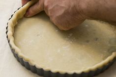 a person holding a wooden stick over a pie crust