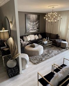 a living room filled with furniture and a chandelier hanging over the top of it