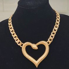 This Uniquely Designed Heart-Shaped Snake Necklace Is Sure To Get The Conversation Started! Goldplated Metal Heart-Shaped Snake With Stone Embellished Eyes. Heavy Duty And Durable Attached Chain. Lobster Claw Clasp. Nice Weight Necklace Size: Approximately 18.5 Inches In Length. Extender Pendant: Approximately 3 X 3 Inches Metal Heart Necklace For Party, Gold Open Heart Necklace For Party, Gold-tone Metal Heart Necklace, Gold-tone Heart-shaped Metal Necklace, Gold-tone Heart Shaped Metal Necklace, Metal Chain Necklace With Heart Charm For Party, Party Chain Necklace With Heart Charm, Gold Heart Pendant Chain Necklace For Party, Snake Pendant