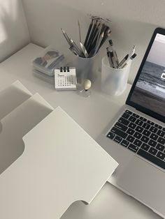 an open laptop computer sitting on top of a white desk