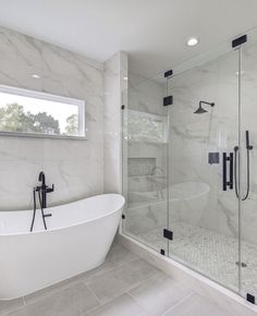 a white bath tub sitting next to a walk in shower