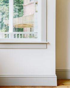 a cat sitting on the floor in front of a window