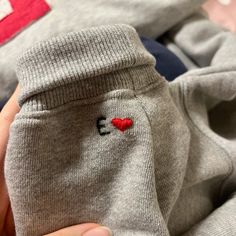 someone is holding their baby's leggings with a heart on it