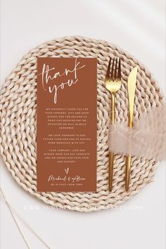 a place setting with goldware and a thank you note on the side, sitting on a wicker plate