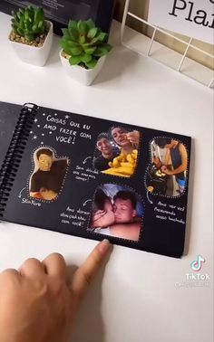 a hand is pointing at a spiral notebook with pictures on it