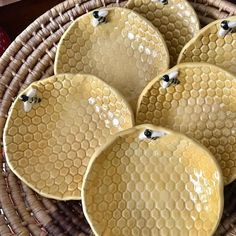 four yellow plates sitting on top of a wicker basket