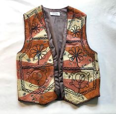 This is a vintage embroidery suede leather patchwork hippie Indian sleeveless jacket vest waistcoat. Also somewhat painted on, like a teardrop shape.  No closure. No pockets.  In good vintage condition, minor signs of wear, the front turns or folds, you can see on the last photo what I mean. Make sure you are aware.  SIZE M/L. Check measurements.  MEASUREMENTS approx.: length 60 cm - 24 inches.  shoulderseam to shoulderseam 40 cm - 16 inches.  armpit to armpit 54 cm - 21 inches.  armpits measure Bohemian Patchwork Vest For Fall, Fall Bohemian Vest With Patchwork, Brown Patchwork Vest For Fall, Fall Bohemian Patchwork Vest, Brown Leather Spring Vest, Brown Leather Vest For Spring, Bohemian Brown Vest For Festival, Brown Bohemian Winter Vest, Bohemian Brown Winter Vest