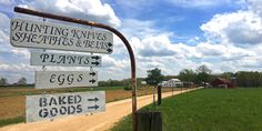 a sign that is on the side of a dirt road in front of some grass