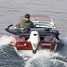 a man riding on the back of a small boat