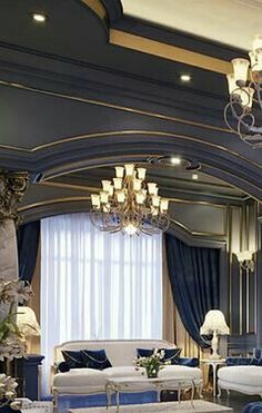 an elegant living room with blue walls and white couches, chandelier and large windows