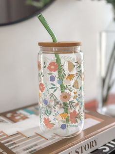 a glass jar with a straw in it sitting on top of a stack of books