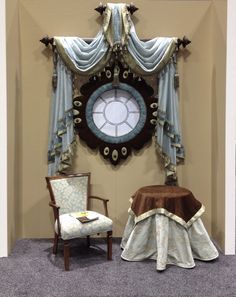 a chair sitting in front of a clock on the wall next to a table with a cloth draped over it