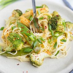 a white plate topped with noodles and vegetables