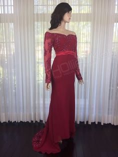 a woman in a red dress standing next to a window