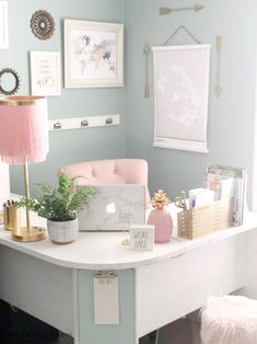 a white desk topped with a laptop computer next to a pink flower vase filled with flowers