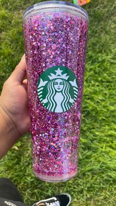 someone holding up a starbucks cup with pink and purple sprinkles