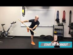 a man holding a baseball bat while standing in front of a wall with exercise equipment