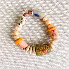 Peach, yellow, and neutral colored sustainable bead bracelet. African prayer bead in Light Tan, peach coral, rosewood, and peach freshwater pearls. Measures 7-8”, size regular (M-L) Sterling silver BelleStyle logo tag. Prayer bead symbolize health, love, good fortune and loyalty. One of a kind. Comes in linen travel pouch. Made in USA. Handmade Orange Beaded Bracelets For Meditation, Orange Gemstone Beaded Bracelets For Meditation, Orange Artisan Hand-strung Bracelets, Artisan Orange Hand-strung Bracelets, Bohemian Peach Round Beads Jewelry, Orange Hand-strung Healing Bracelets, Orange Bracelets With Wooden Round Beads, Orange Wooden Beaded Bracelets As Gift, Orange Wooden Beads Bracelet As Gift