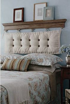 a bedroom with blue walls and white bedding, two framed pictures on the headboard