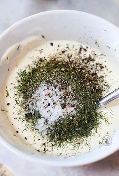 a white bowl filled with cream and herbs