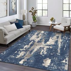 a living room filled with furniture and a blue rug on top of a hard wood floor