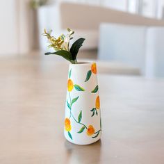 a painted vase with flowers in it on a table