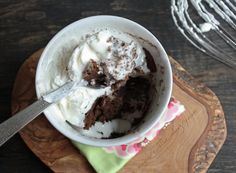 a bowl filled with ice cream on top of a wooden cutting board