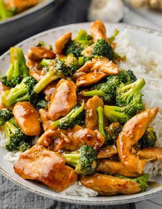 chicken and broccoli stir fry on top of rice in a white bowl with a fork