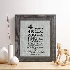 a wooden frame with a family birth date on it next to some vases and a toy horse