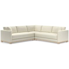 a white sectional couch sitting on top of a white floor next to a wooden frame