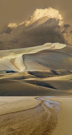 the sky is very cloudy and it looks like sand dunes