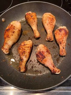 chicken legs are cooking in a pan on the stove