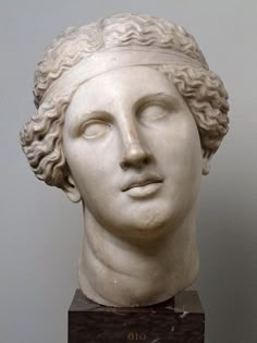 a white marble bust of a man with curly hair