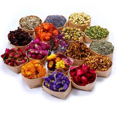 a bunch of different types of flowers in small bags on a white surface with scissors