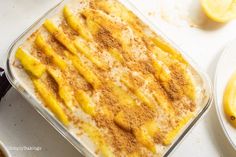 a casserole dish with lemons and cinnamon on the side, ready to be eaten