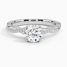 a white gold engagement ring with an oval cut diamond in the center and pave set shoulders