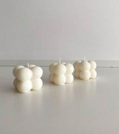 three white candles sitting next to each other on a table