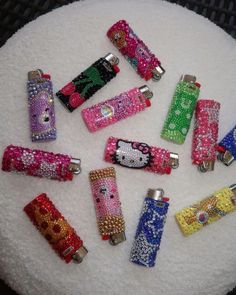 hello kitty lighters are sitting on top of a white cake covered in colorful beads