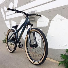 a bike parked next to a white wall