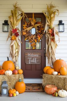 a front porch decorated for fall with hay bales and pumpkins