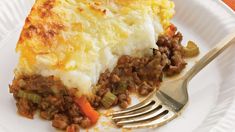 a piece of meat and cheese pie on a plate with a fork