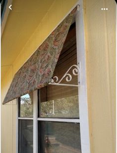 an awning on the side of a yellow building