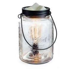 a glass jar with a candle inside on a white background