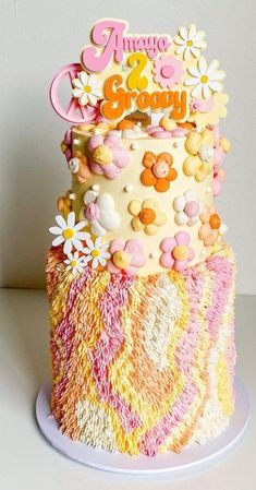 a multi - tiered cake decorated with flowers and the words happy birthday on top