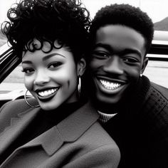 two people sitting in a car smiling at the camera with their heads turned to the side