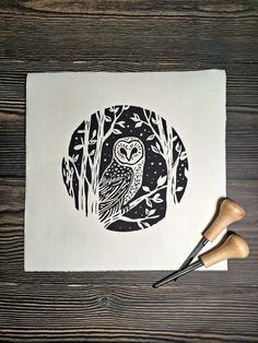 an owl is sitting on top of a piece of paper next to two rubber stamps