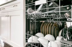 an open dishwasher with dishes in it