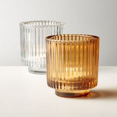 two glass vases sitting next to each other on a table