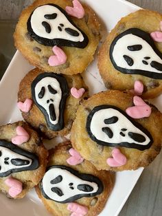 some cookies with icing on them are decorated to look like ghost faces and mouths